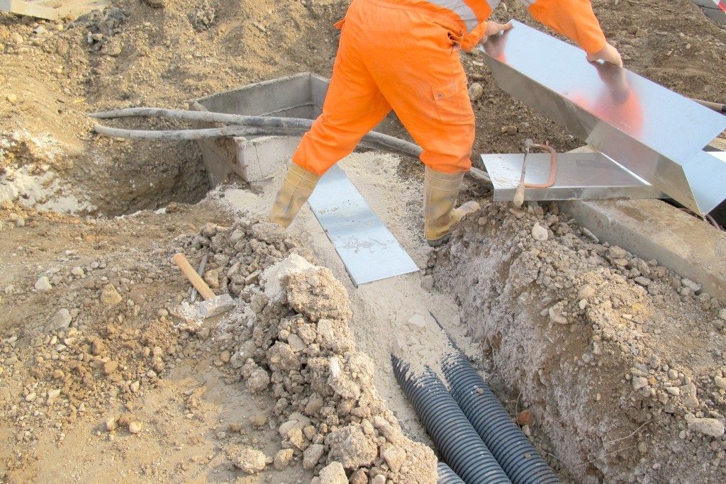 man fixing the pipes on the road