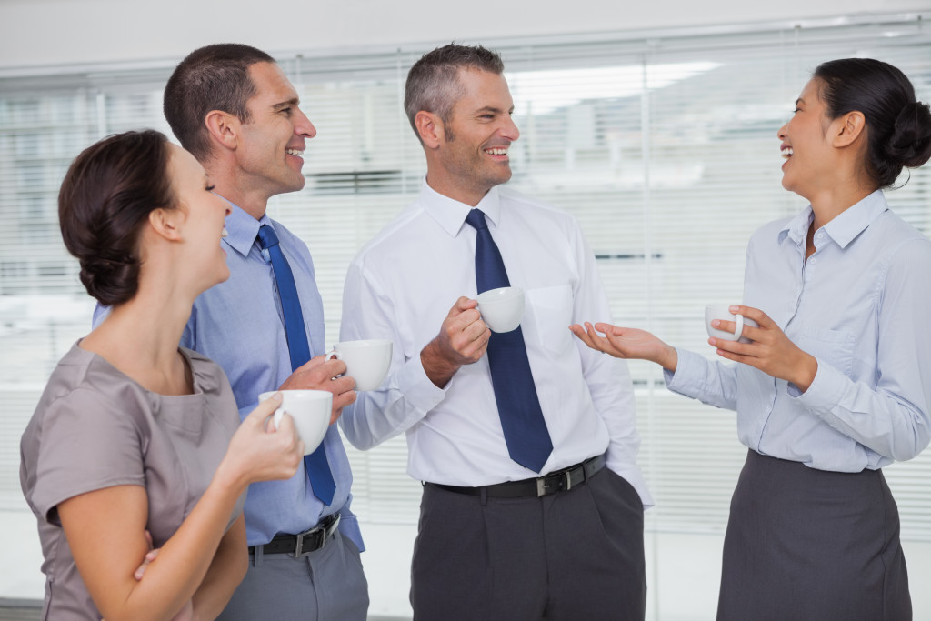 group of professionals mingling while holding a mug