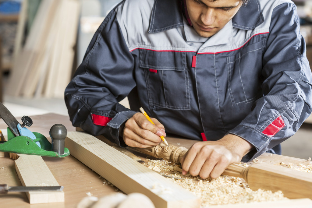 Worker writes marks on wood product