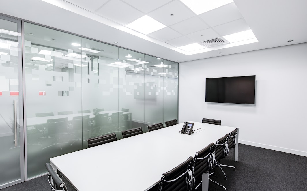 Rectangular White Table With Rolling Chairs Inside Room