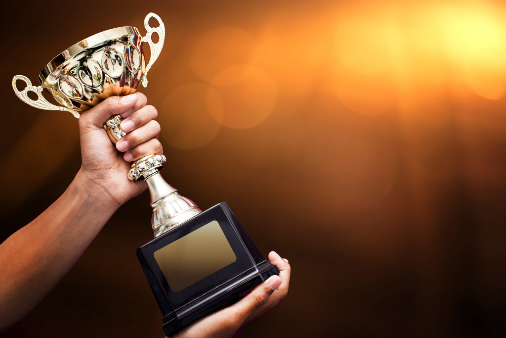 holding a trophy in an isolated background