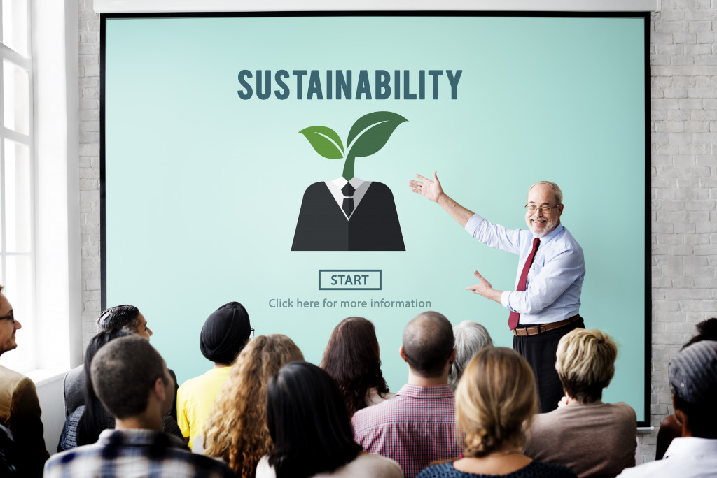 A businessman giving a presentation on SUSTAINABILITY